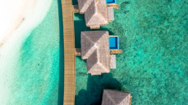 Overwater villas along a jetty seen from above