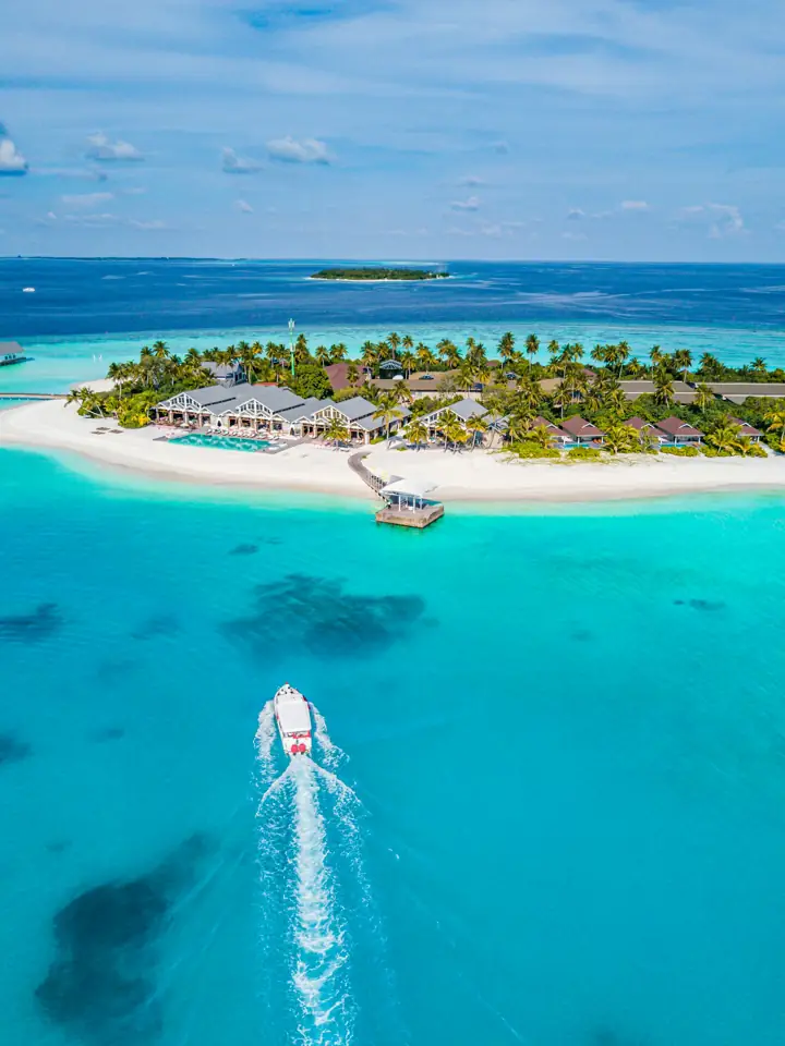 Aerial view of a Maldives island with a speedboat