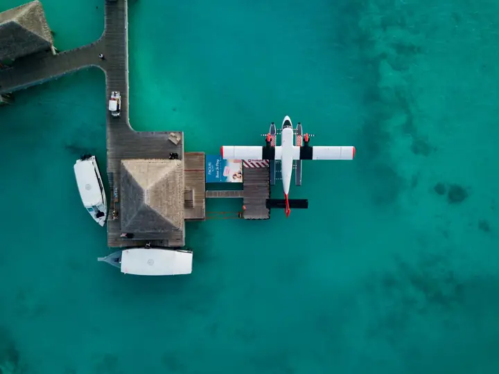 Seaplane moored at a wooden jetty in turquoise water